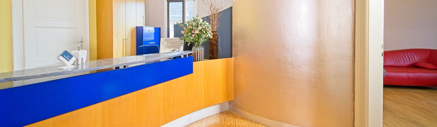 Empfangstheke in der Praxis für Kieferorthopädie in Weinheim mit anschließendem Wartebereich